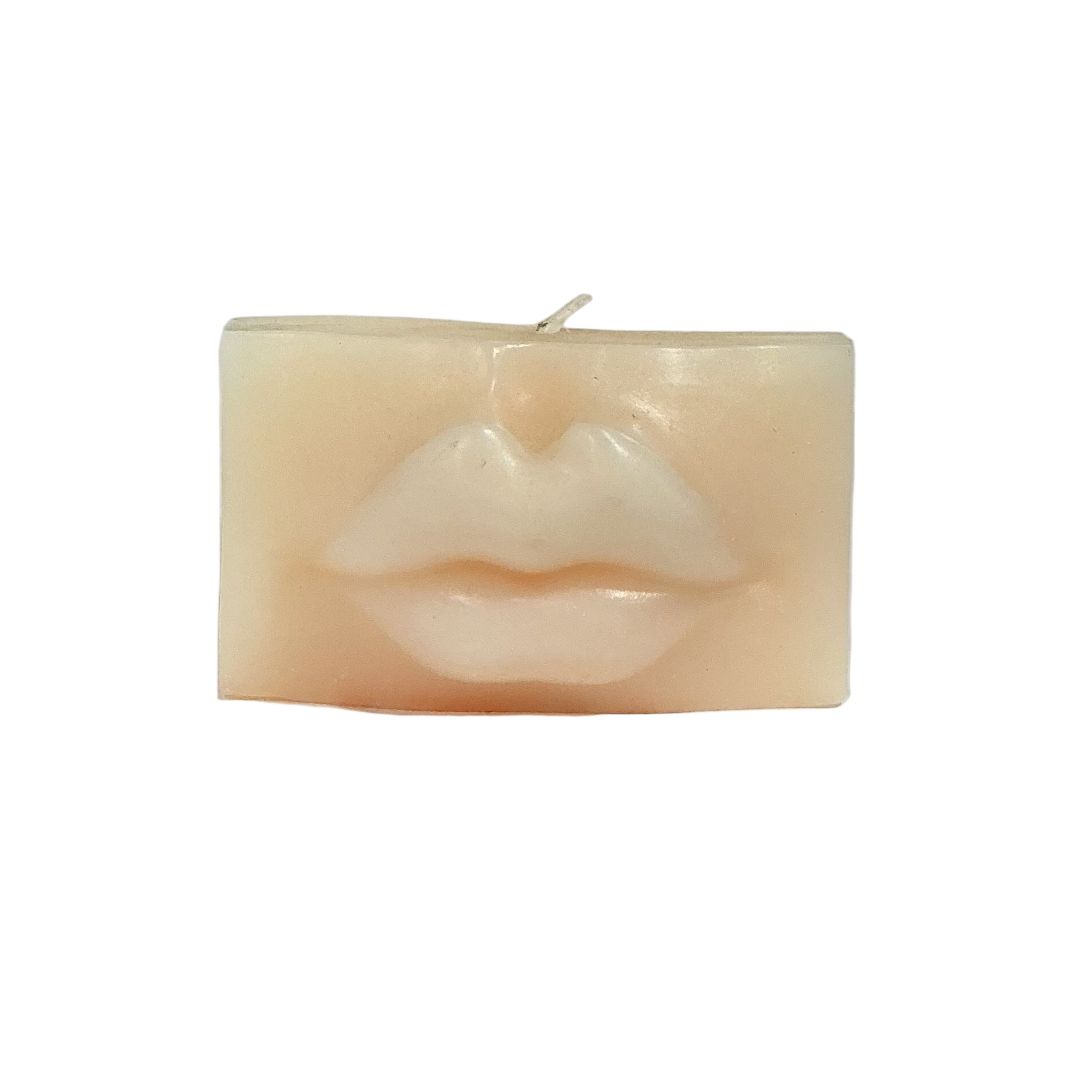 Rectangular candle with a face design on a light gray background