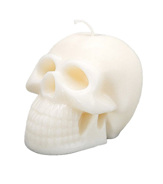 Skull-shaped candle on a gray background
